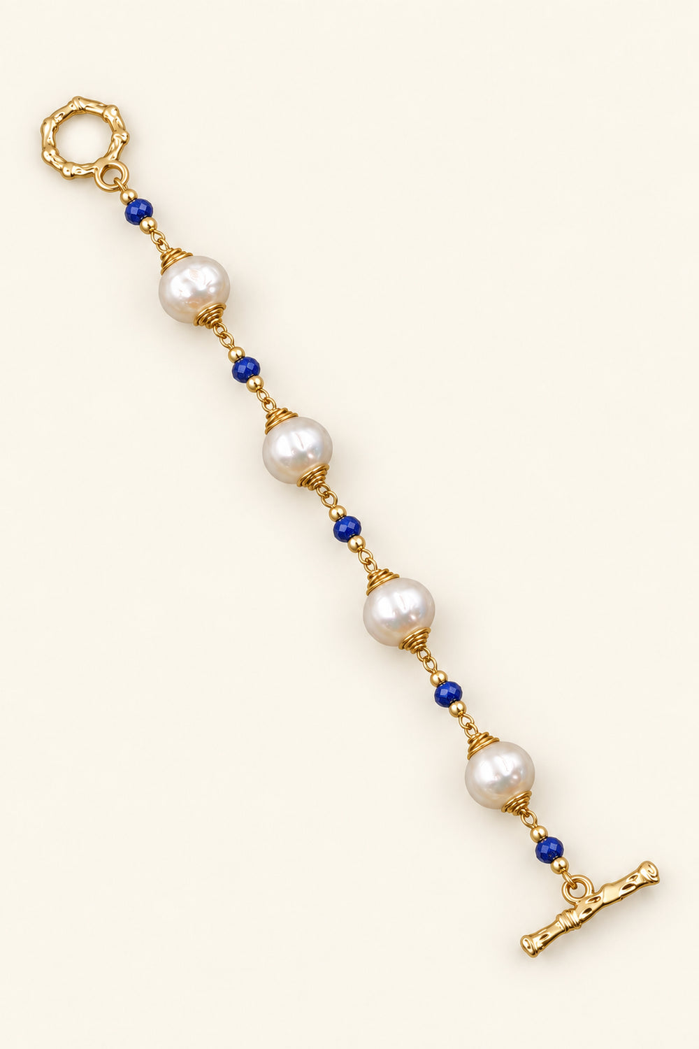 APAERZ AZURÉA goldfarbenes Perlenarmband mit weißen Süßwasserperlen, blauen Kyanitsteinen und OT-Verschluss, ausgestreckt dargestellt
