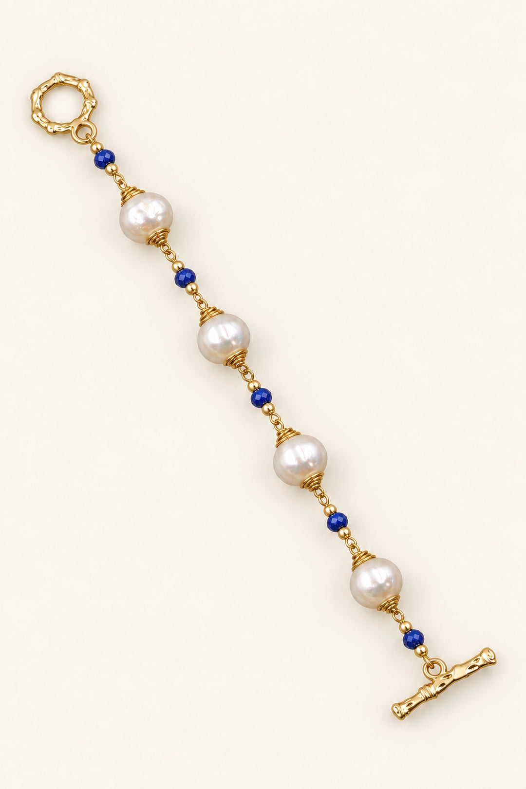 APAERZ AZURÉA goldfarbenes Perlenarmband mit weißen Süßwasserperlen, blauen Kyanitsteinen und OT-Verschluss, ausgestreckt dargestellt