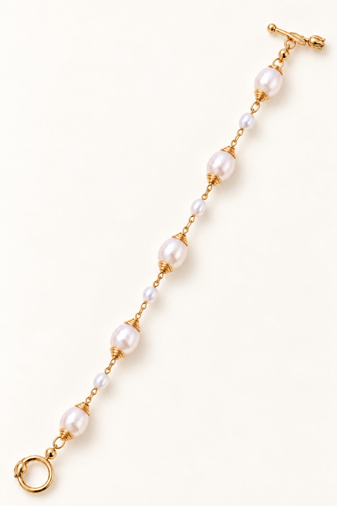 APAERZ TULÉA goldfarbenes Perlenarmband mit fünf großen und vier kleinen Süßwasserperlen sowie Tulpenverschluss, ausgestreckt dargestellt