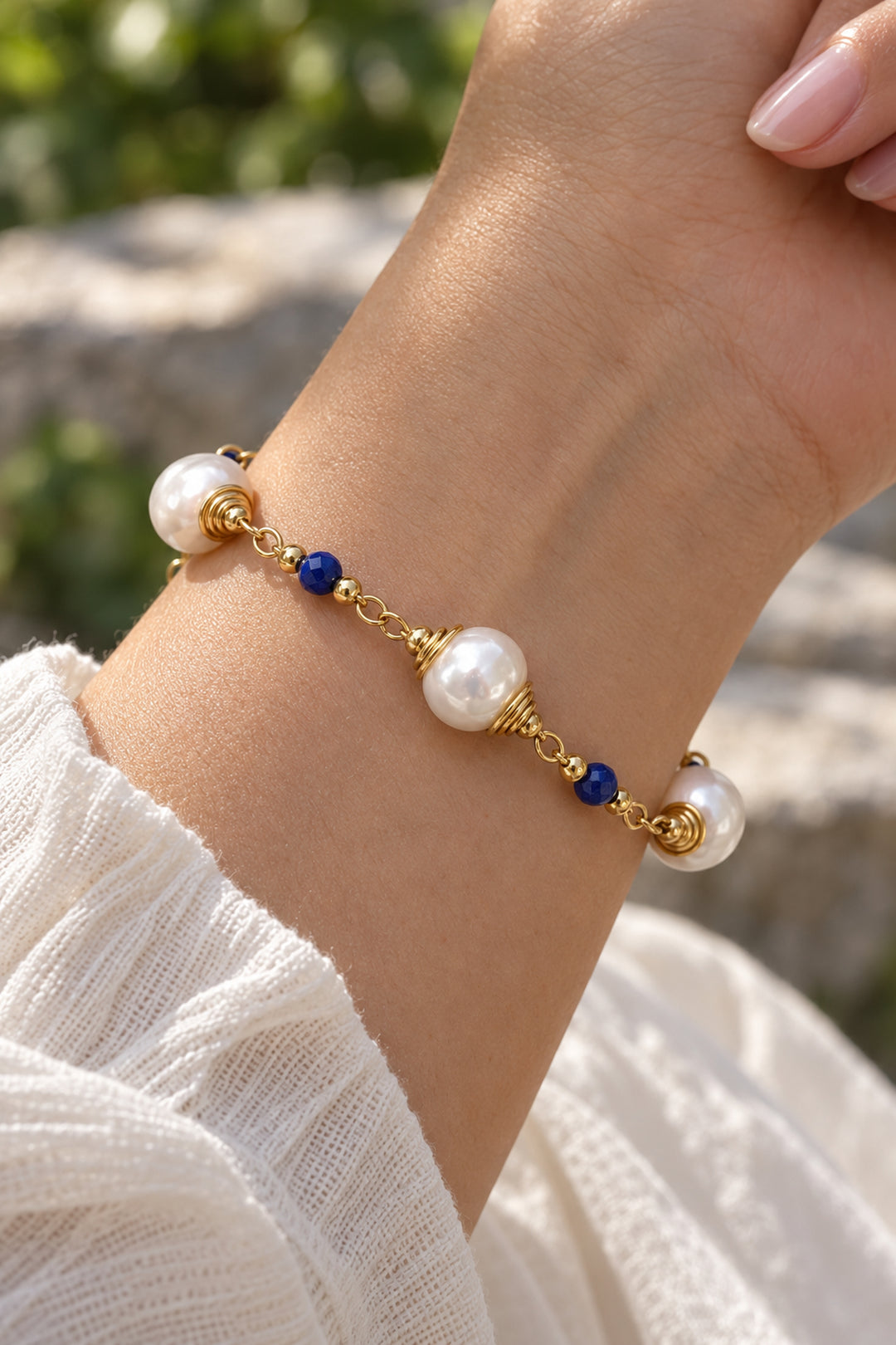 Nahaufnahme des APAERZ AZURÉA Perlenarmbands mit weißen Perlen und blauen Kyanitsteinen am Handgelenk